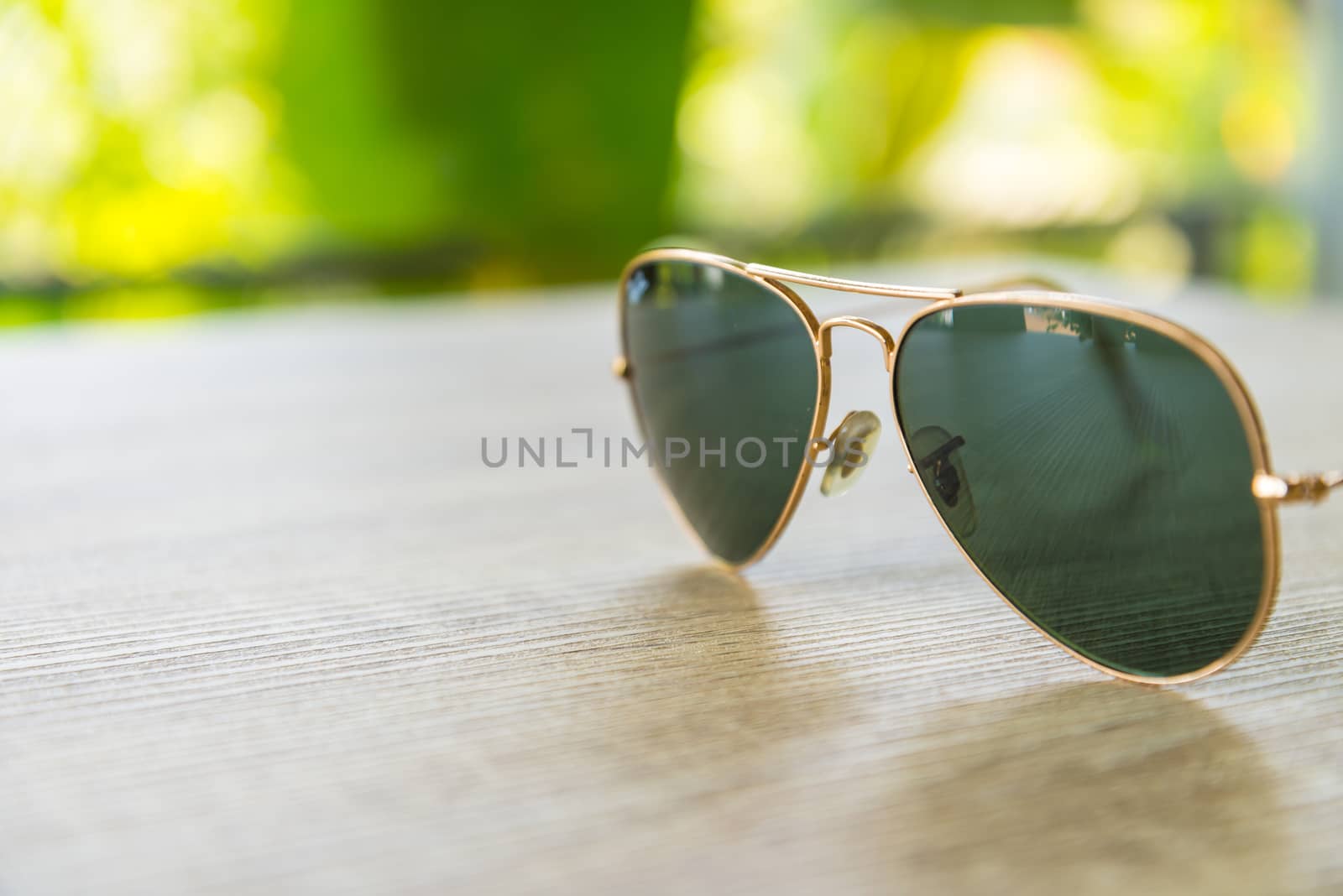 Sunglasses resting on a wooden table.