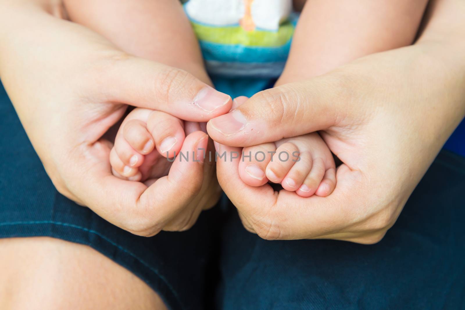 Baby feet in mother's hands, concept of love and family,sensitive focus