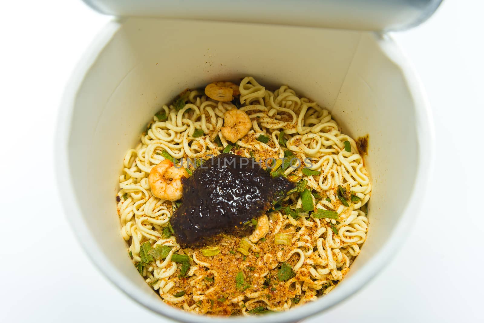 cooked instant cup noodle with ingredient on white background