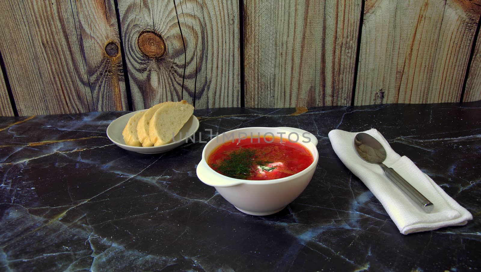 Russian national soup Borsch spoon on a napkin spoon and saucer with bread.