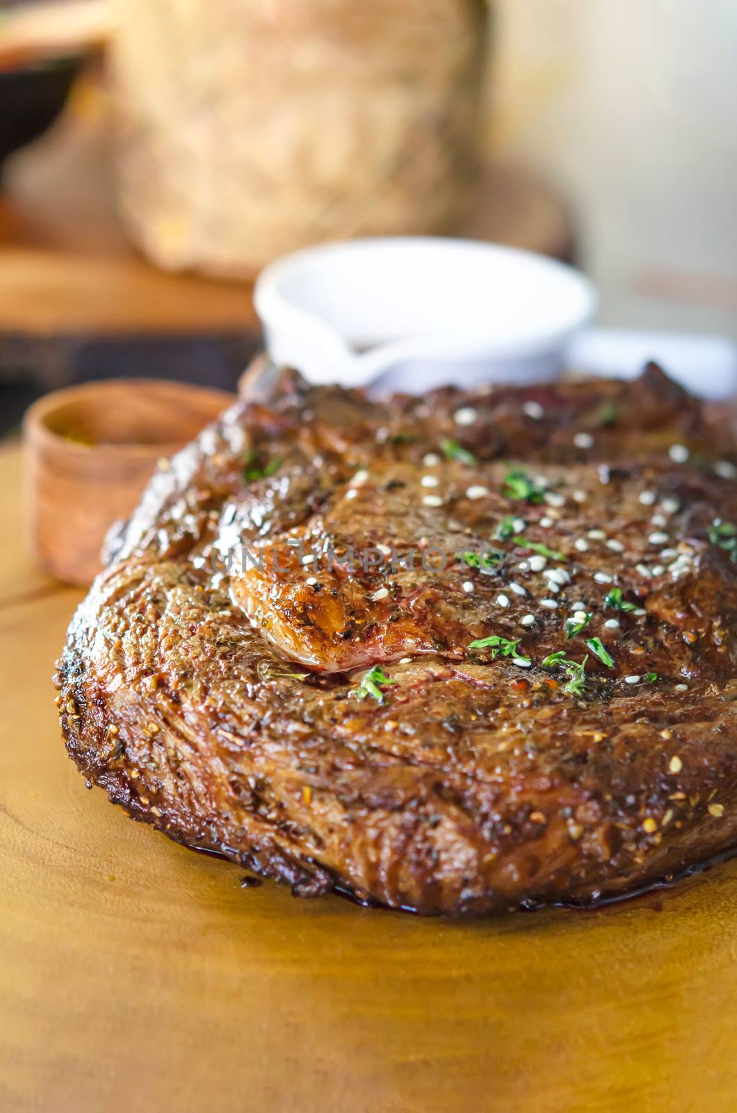 grilled beef steaks with spices on wooden cutting board