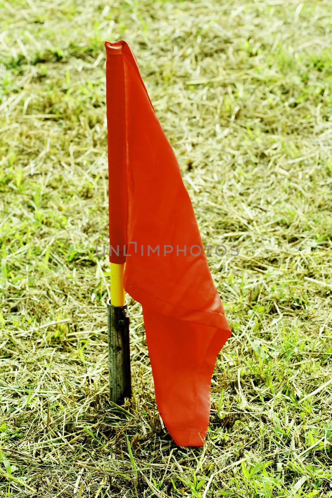 red flag stick on grassland.