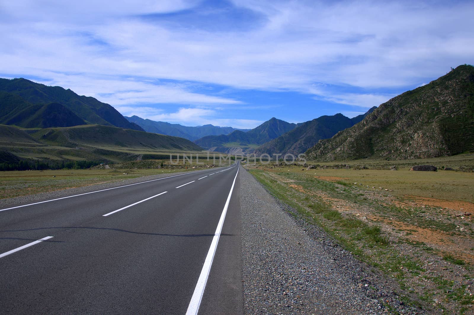 Asphalt road going through a green valley sandwiched between the mountains. Altai, Siberia, Russia. Landscape. by alexey_zheltukhin