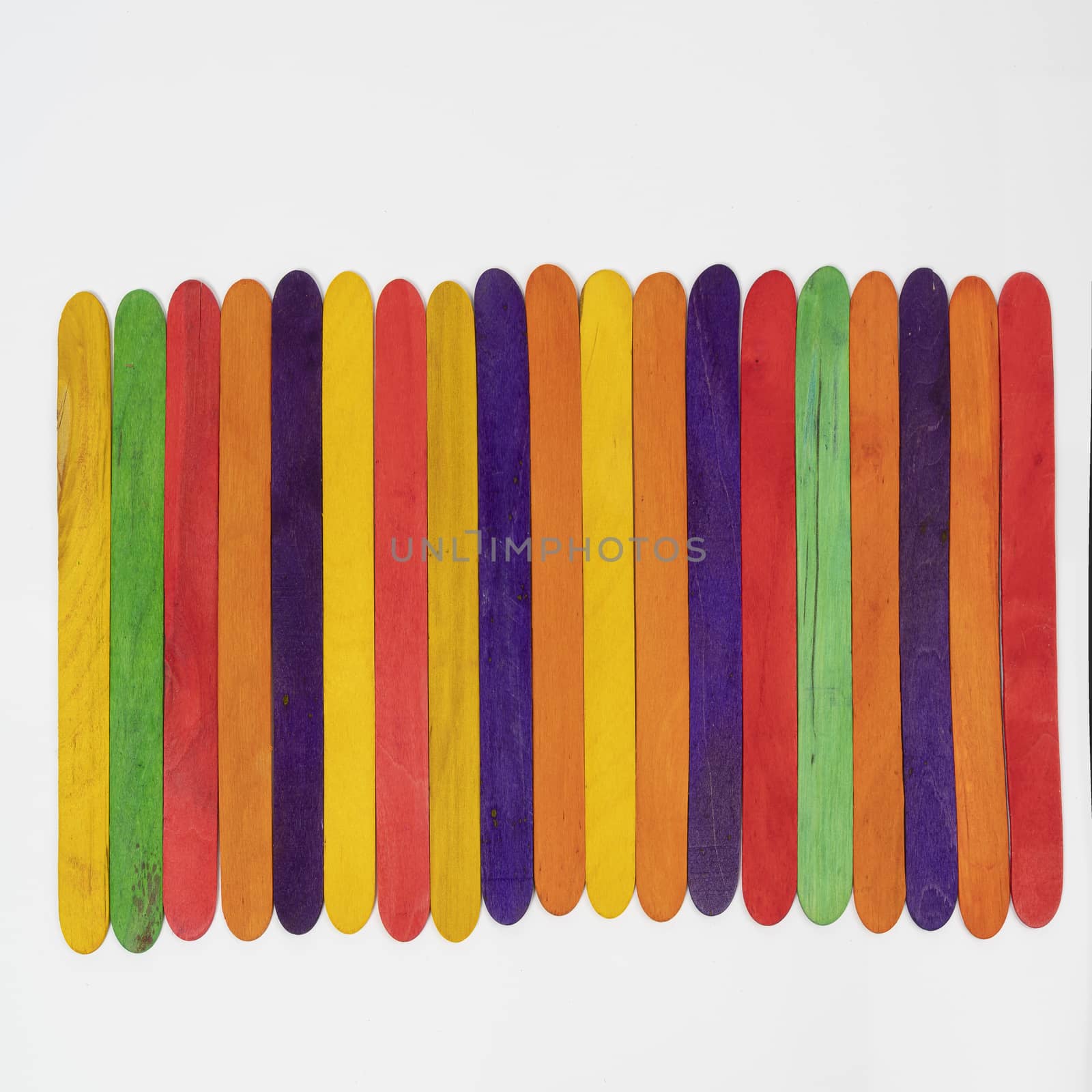 some colored wooden slats arranged on a white surface