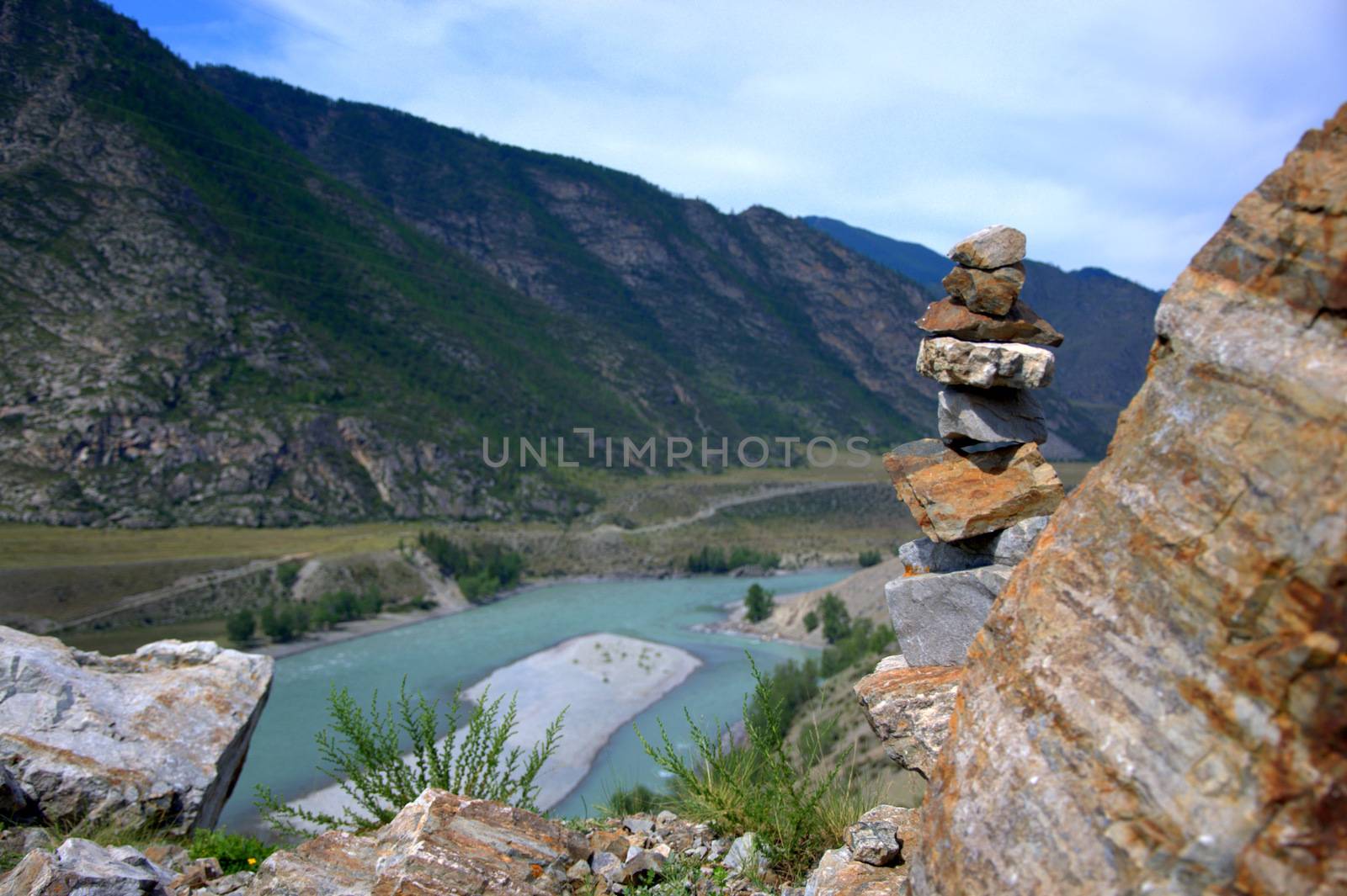 Socral pyramid on the top of the mountain, against the background of the bend of the turquoise Katun River. Altai, Siberia, Russia.