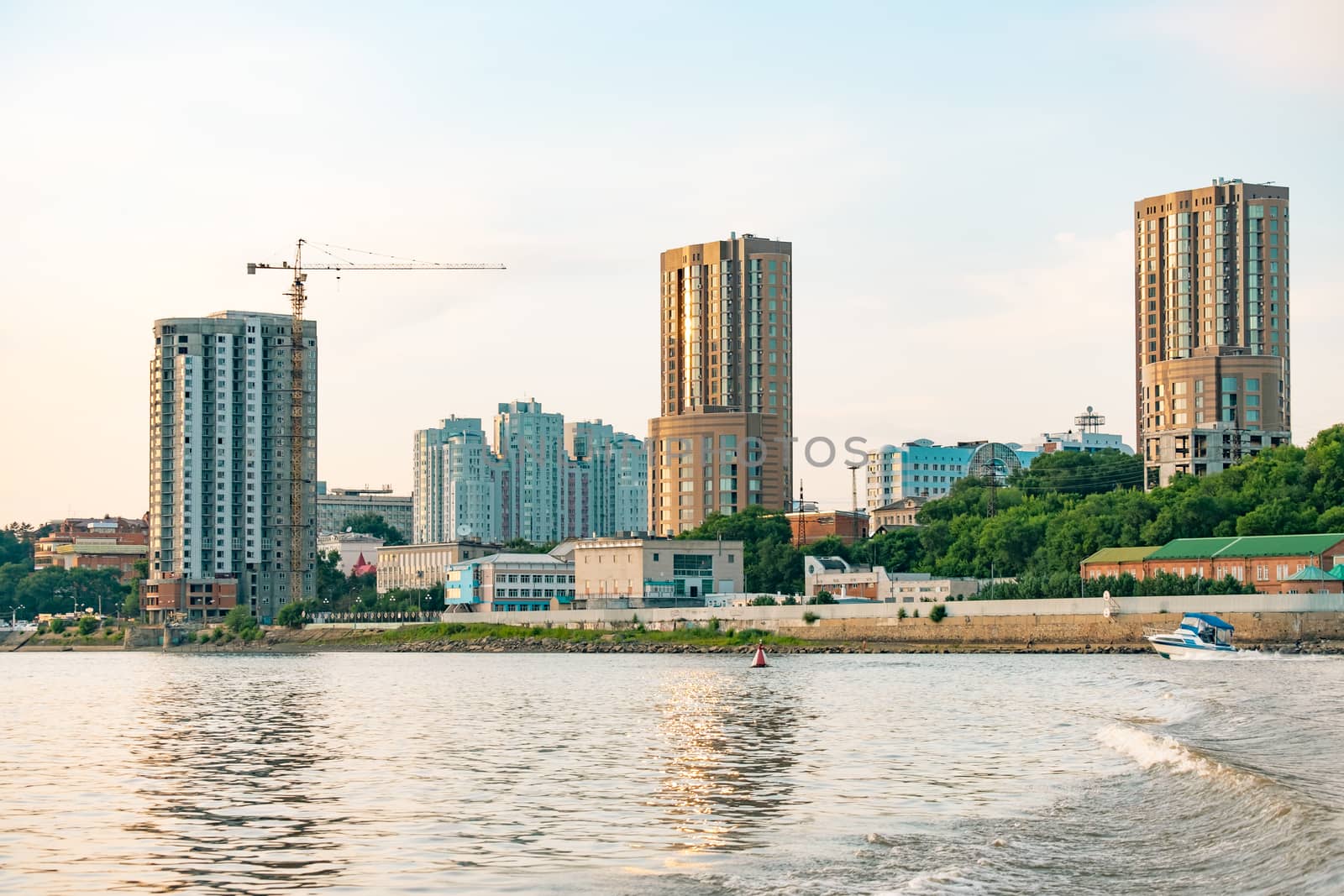 View of the city of Khabarovsk from the Amur river. Urban landscape in the evening at sunset