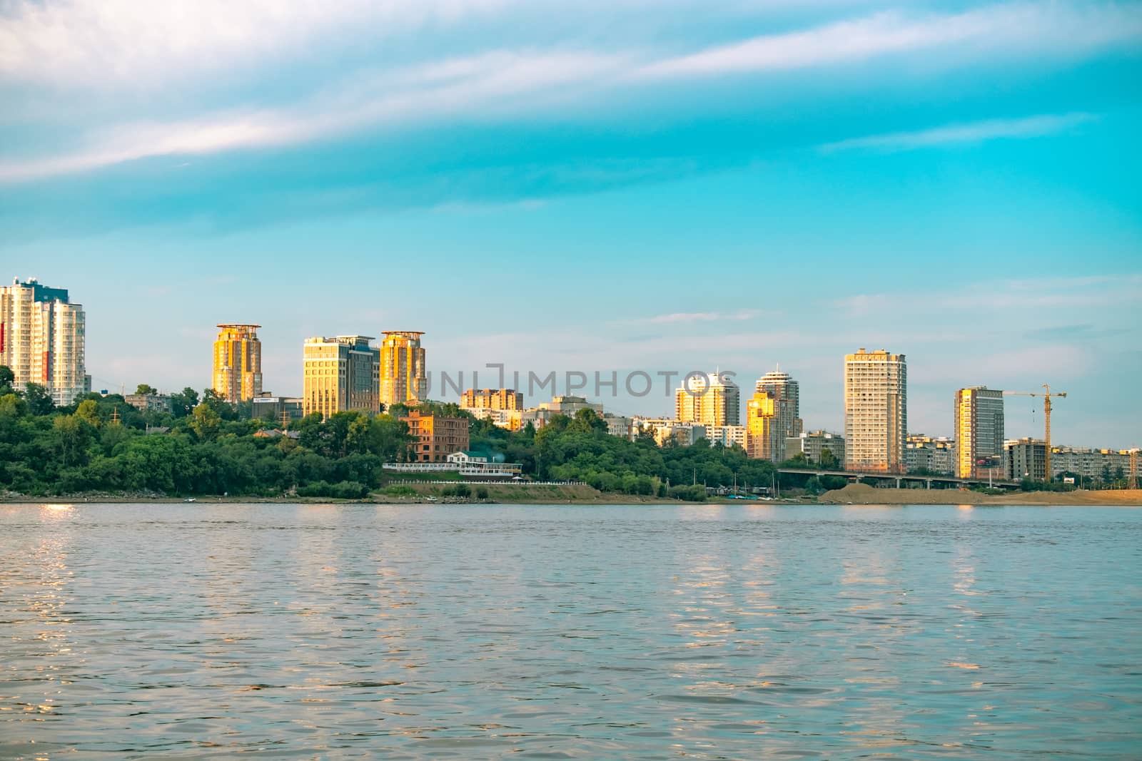 View of the city of Khabarovsk from the Amur river. Urban landscape in the evening at sunset. by rdv27