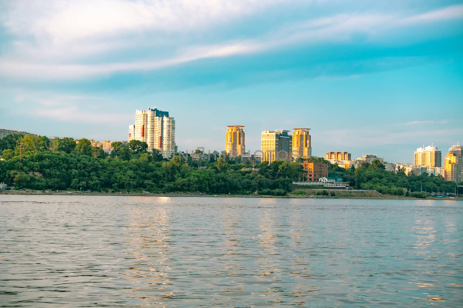 View of the city of Khabarovsk from the Amur river. Urban landscape in the evening at sunset