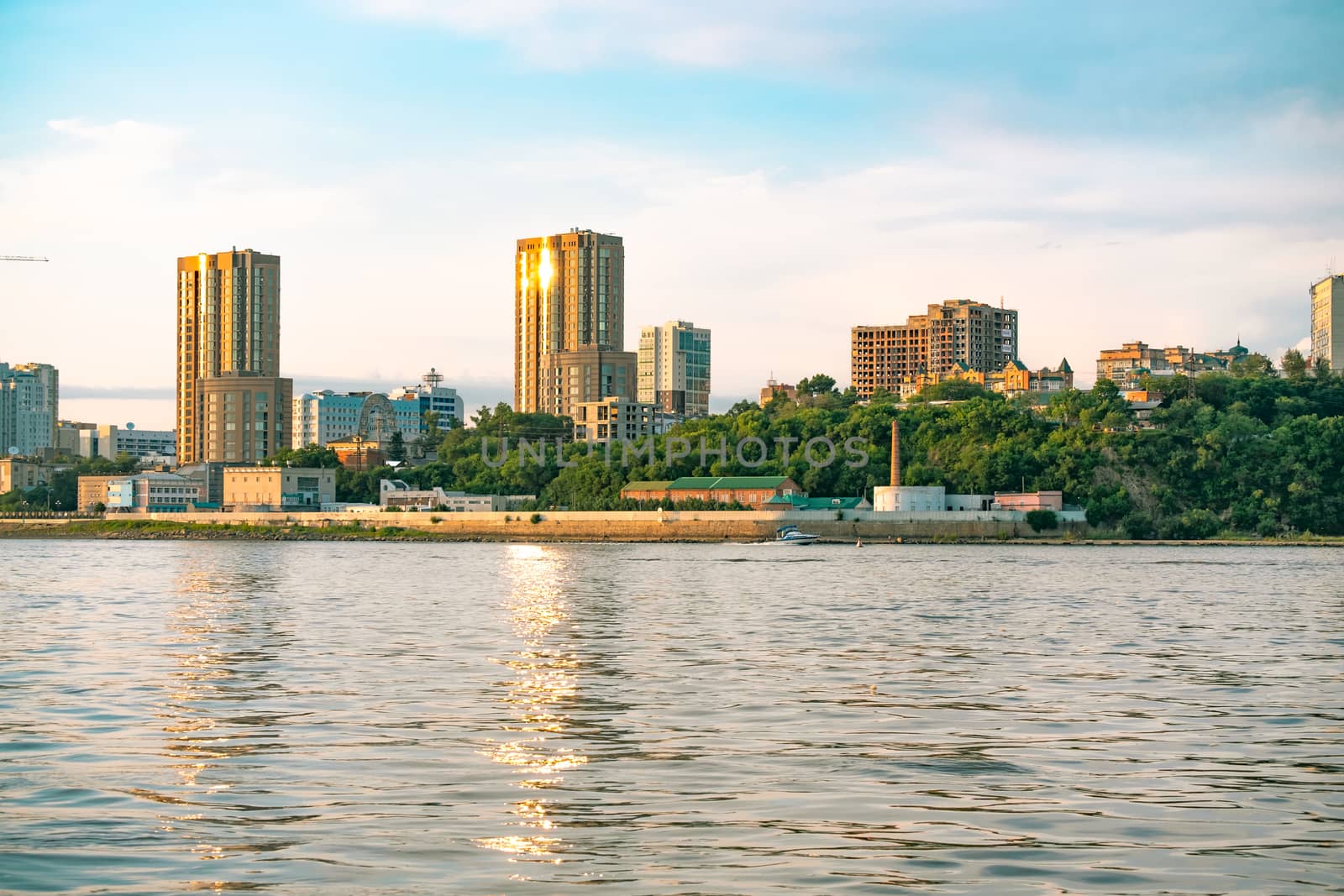 View of the city of Khabarovsk from the Amur river. Urban landscape in the evening at sunset. by rdv27