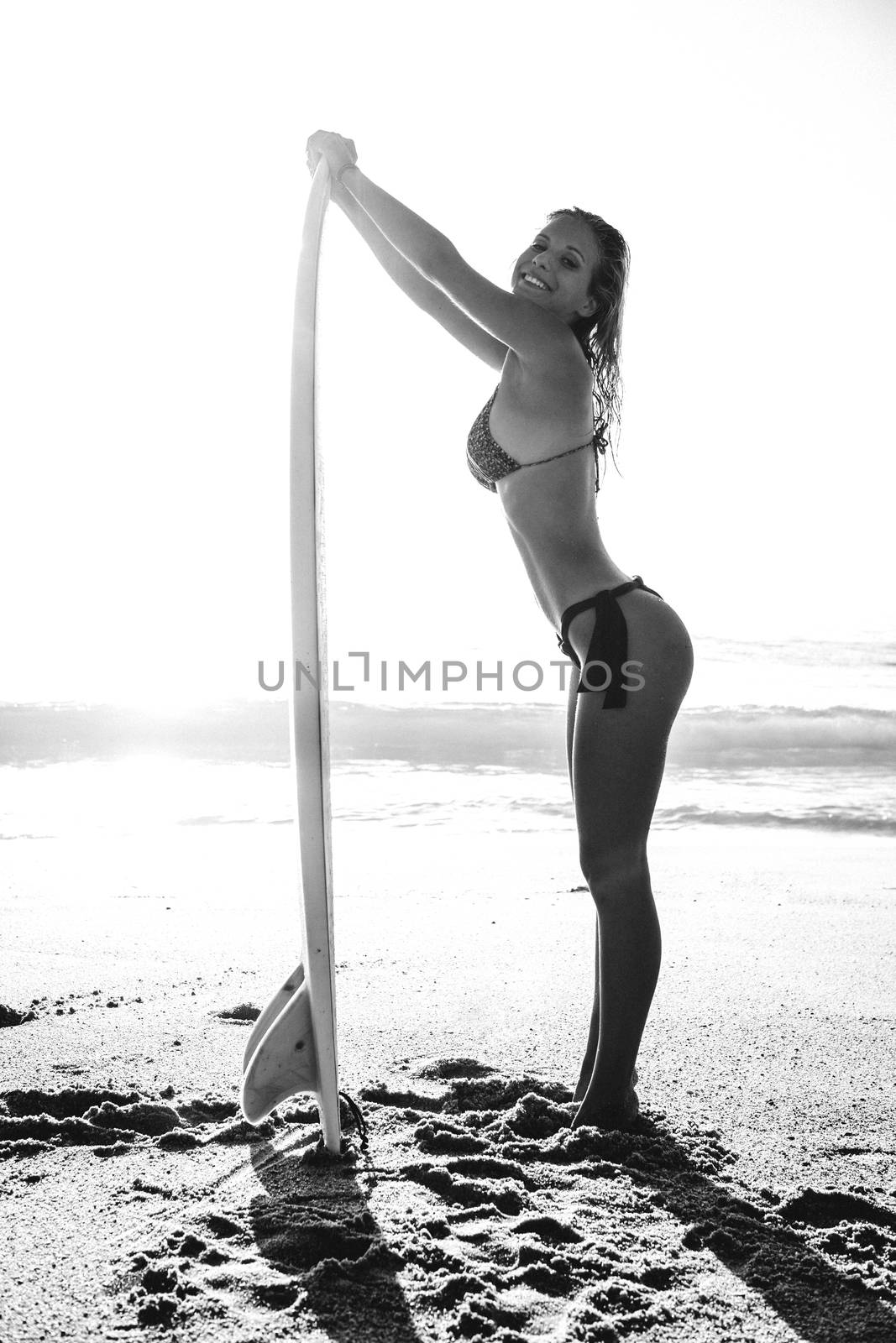 Beautiful and sexy girl posing with her surfboard
