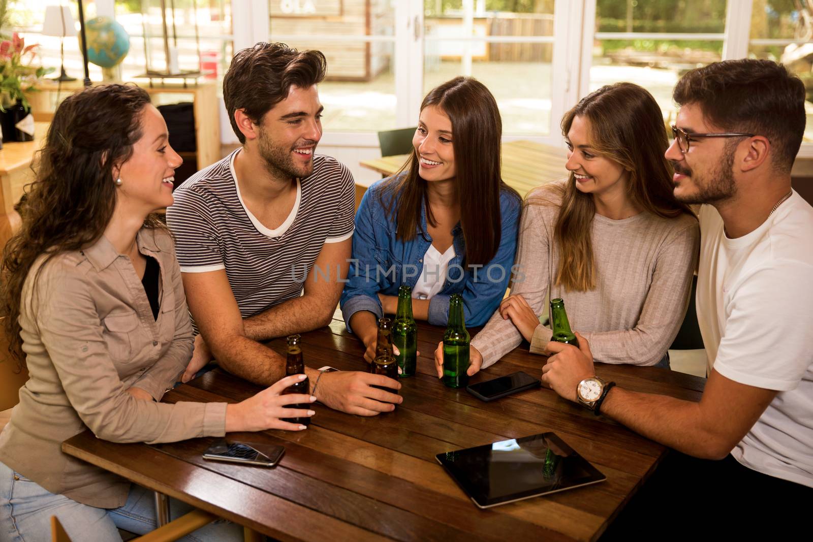 A group of friends at the bar drinking a beer 