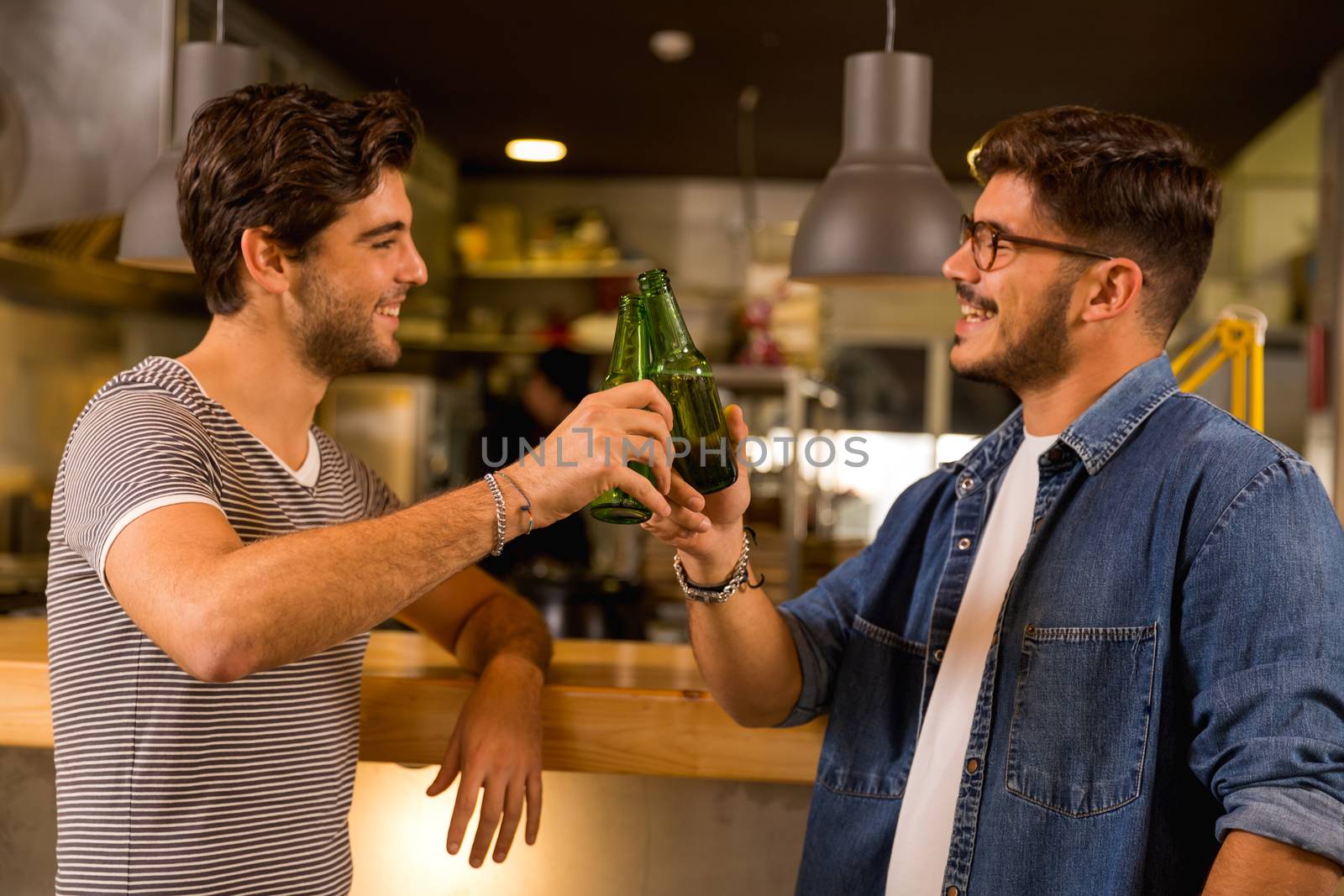 Two friends having a drink at the pub and making a toast 