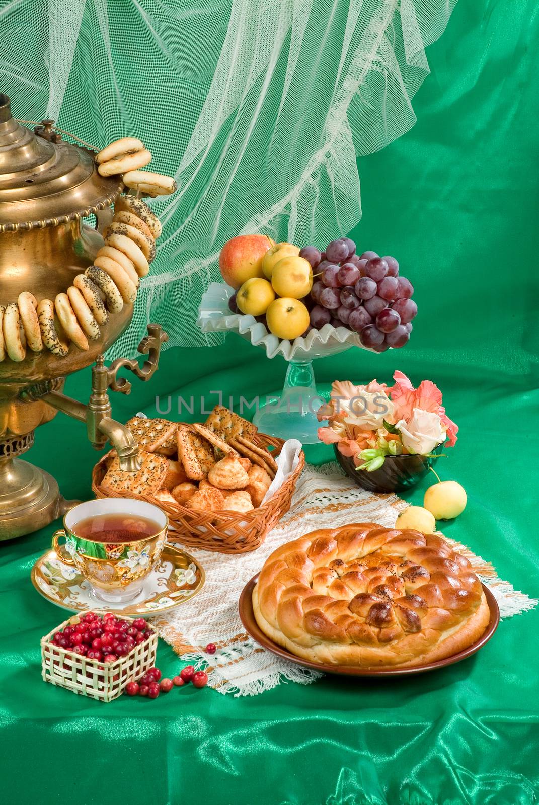 Russian traditional water boiler, fruits and bread on a studio background