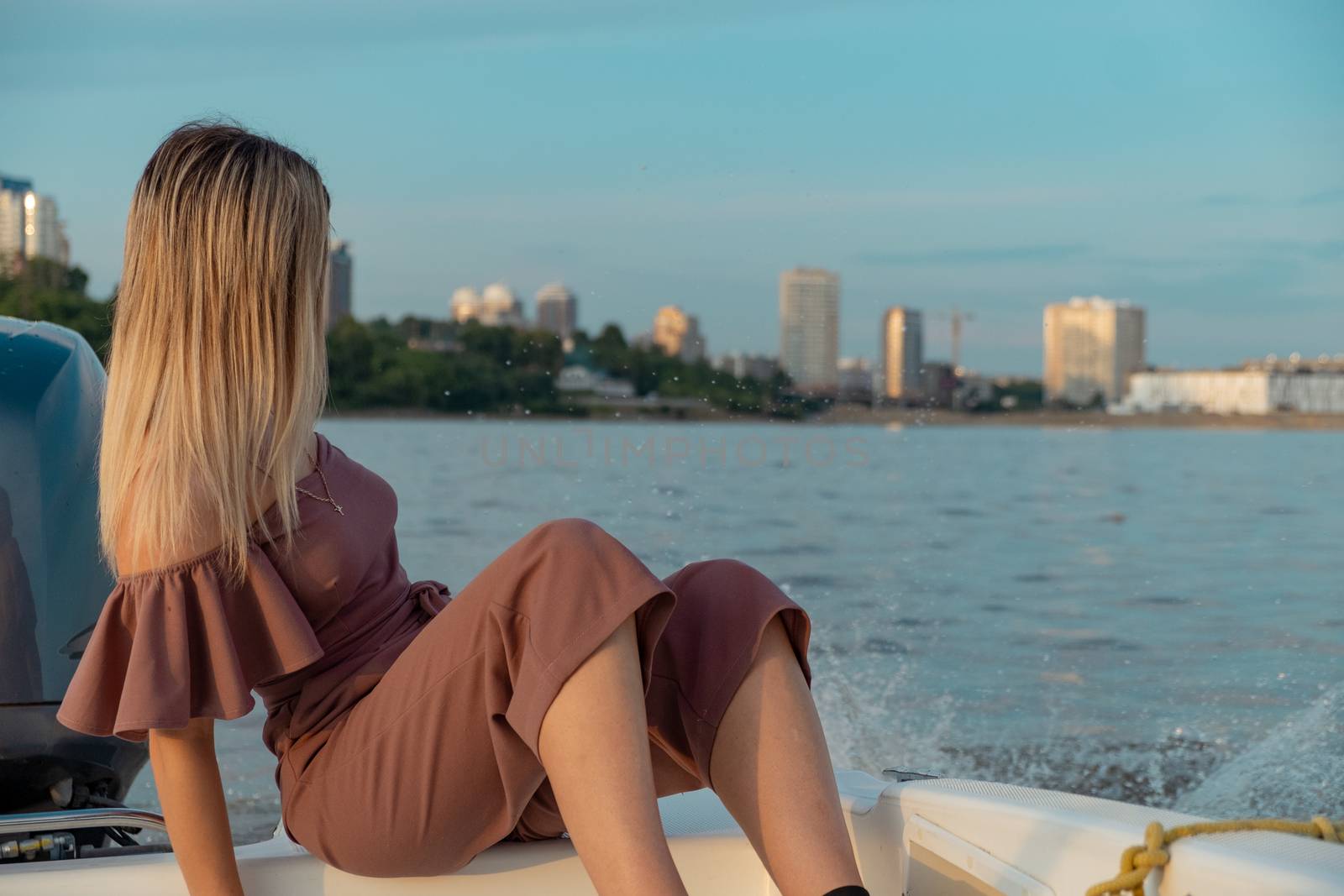 The guy jumps into the water from the boat. A beautiful girl is watching him