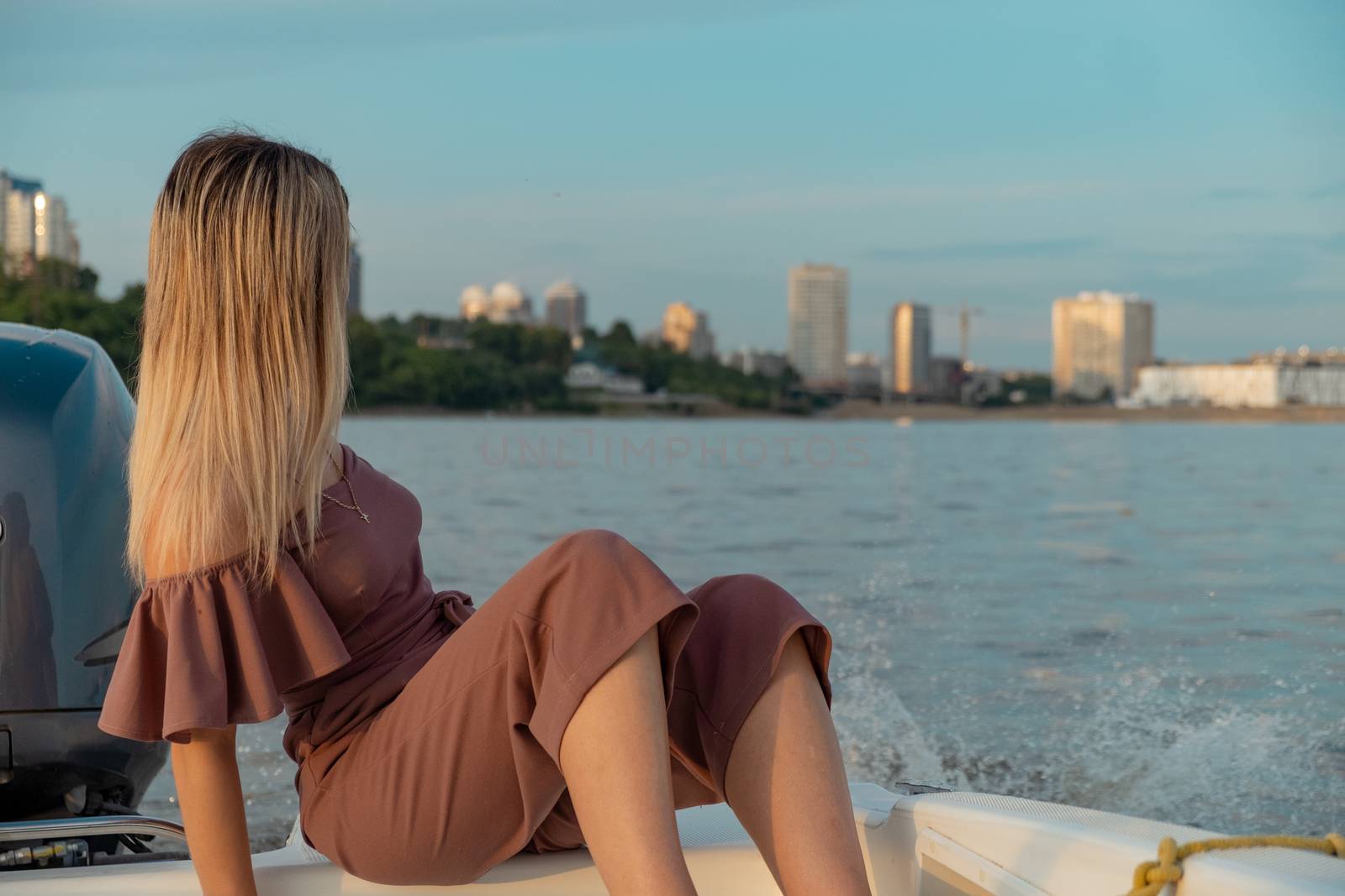 The guy jumps into the water from the boat. A beautiful girl is watching him