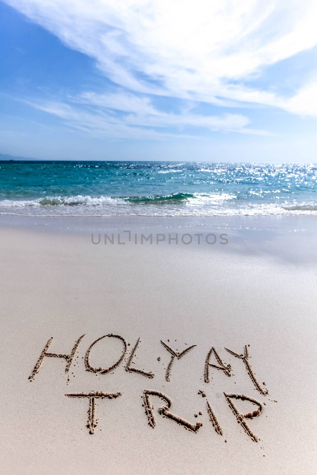 Holiday trip handwriting on tropical sea beach