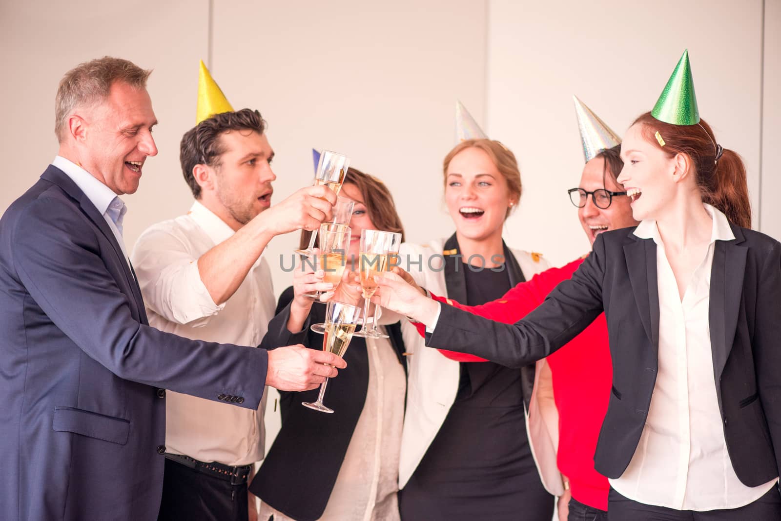 People in business outfit celebrating something in the office clinking glasses of champagne