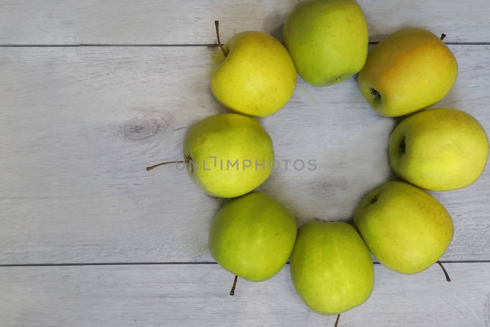 apples medium-sized green juicy lie on the wooden surface there is room for text