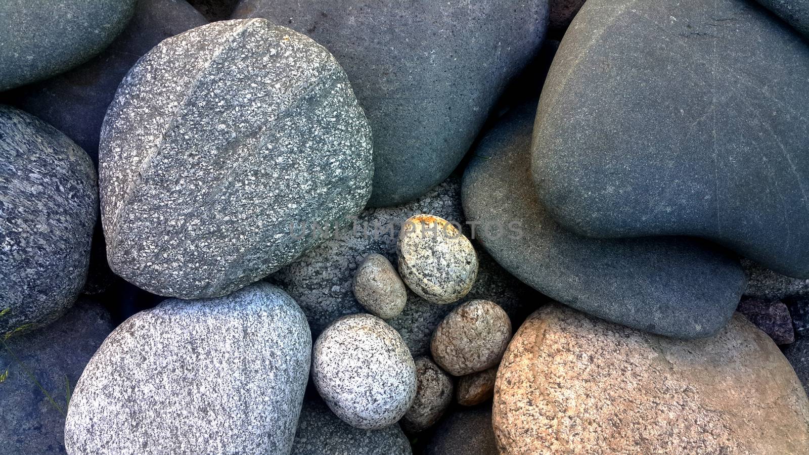 photo of large stones rounded streamlined shape of different shades of gray.