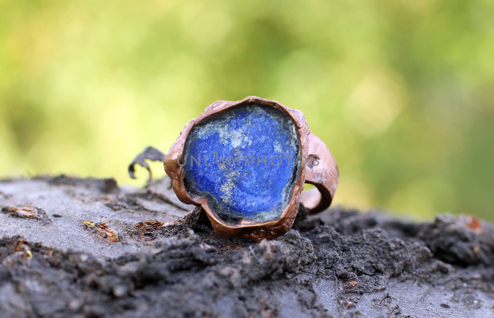 the Hand made copper ring with blue semiprecious stone on the wooden background