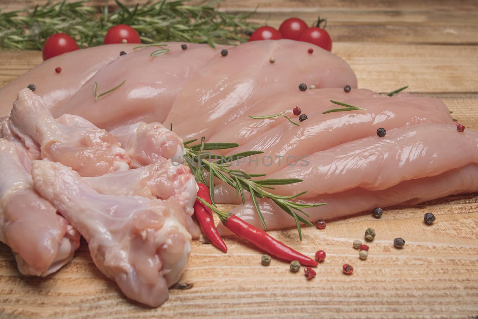 .Raw chicken meat on wooden board. Healthy eating.Raw, fresh chicken meat platter on a wooden surface with spices for cooking.