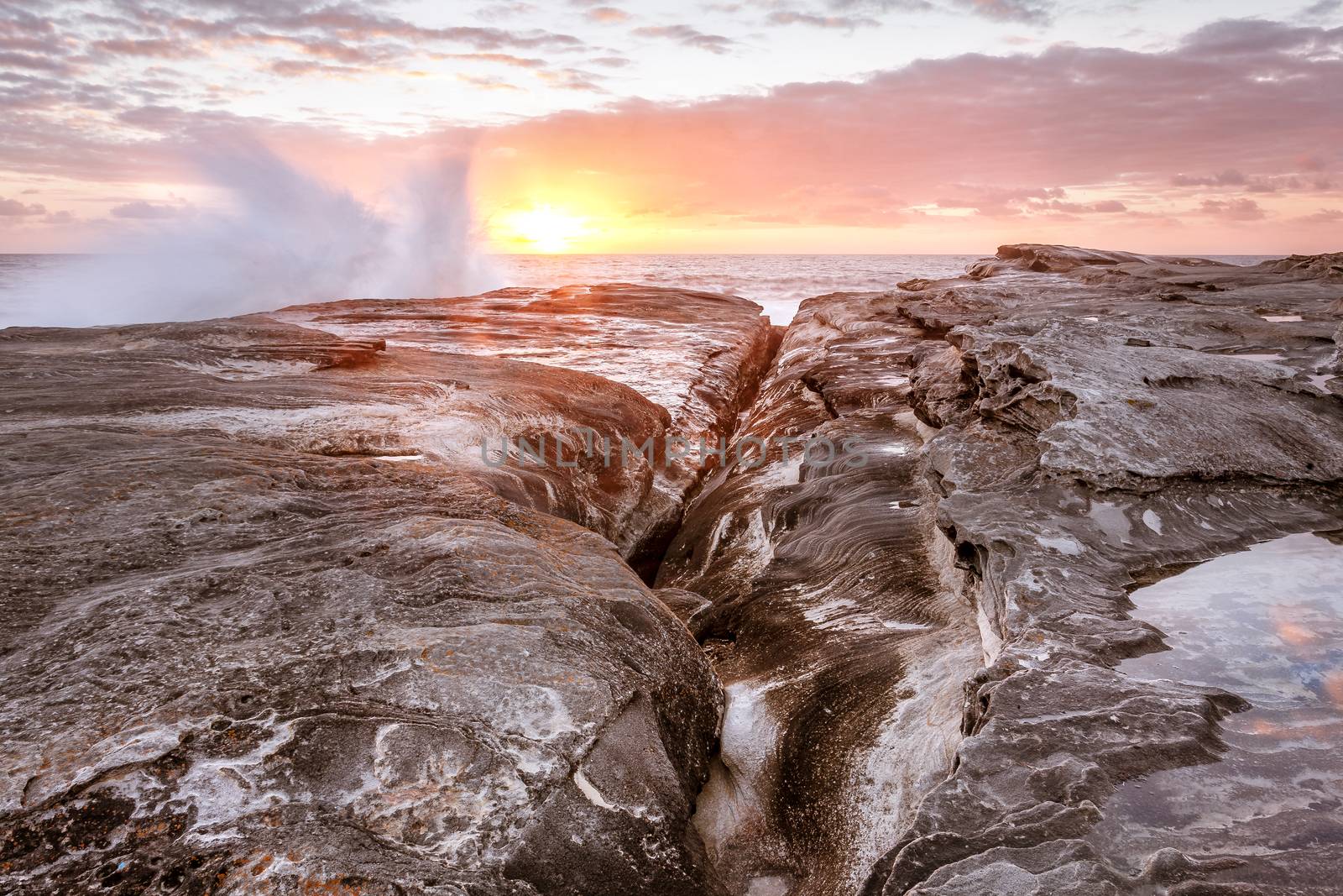 Waves splash up onto rocks on coast of Sydney by lovleah