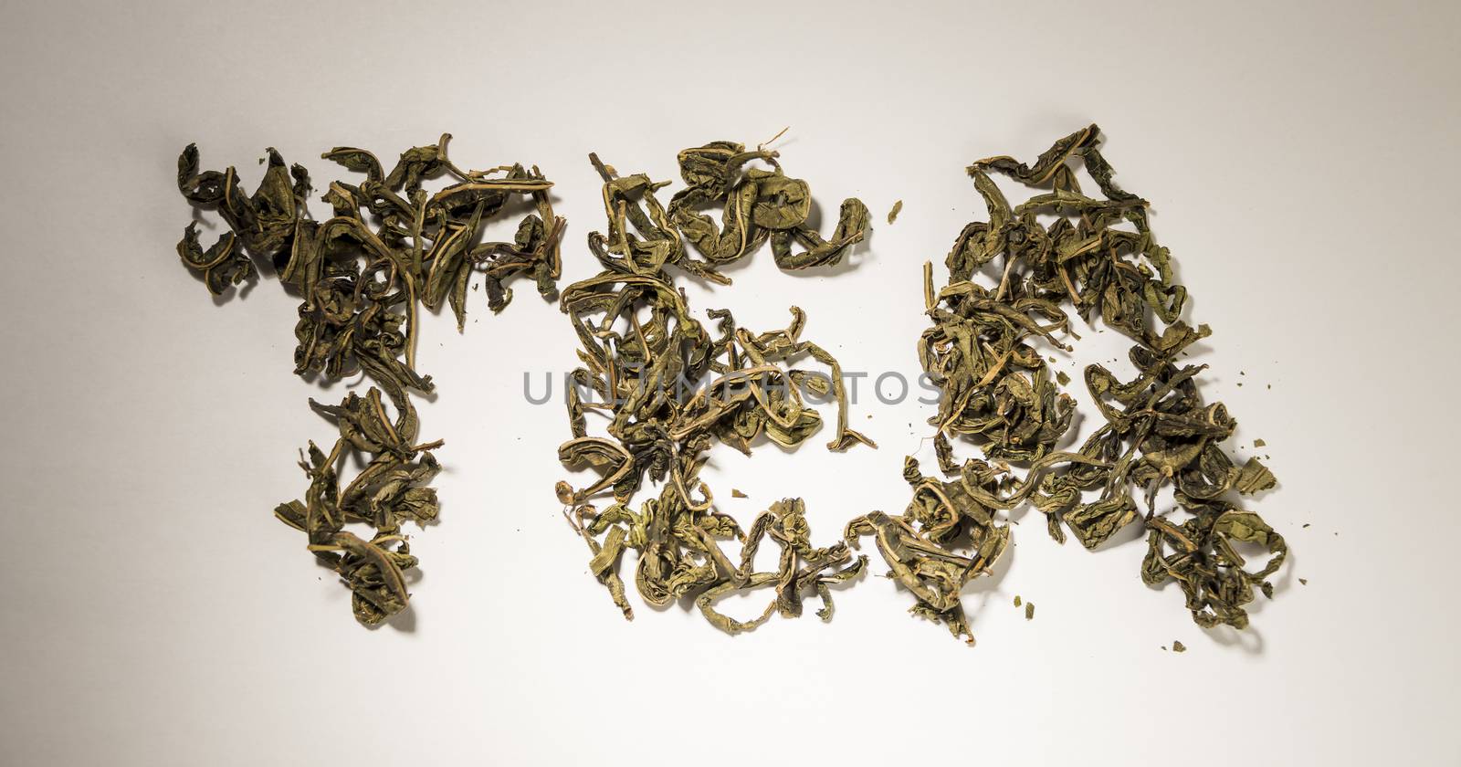 inscription tea from green tea leaves on a white background by butenkow