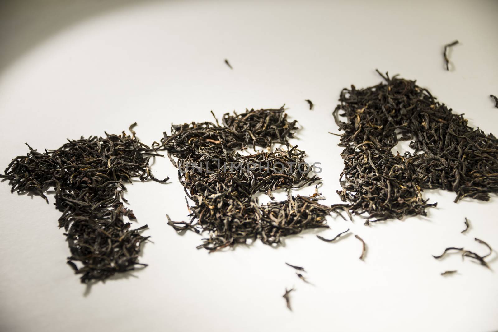 inscription tea from black tea leaves on a white background.