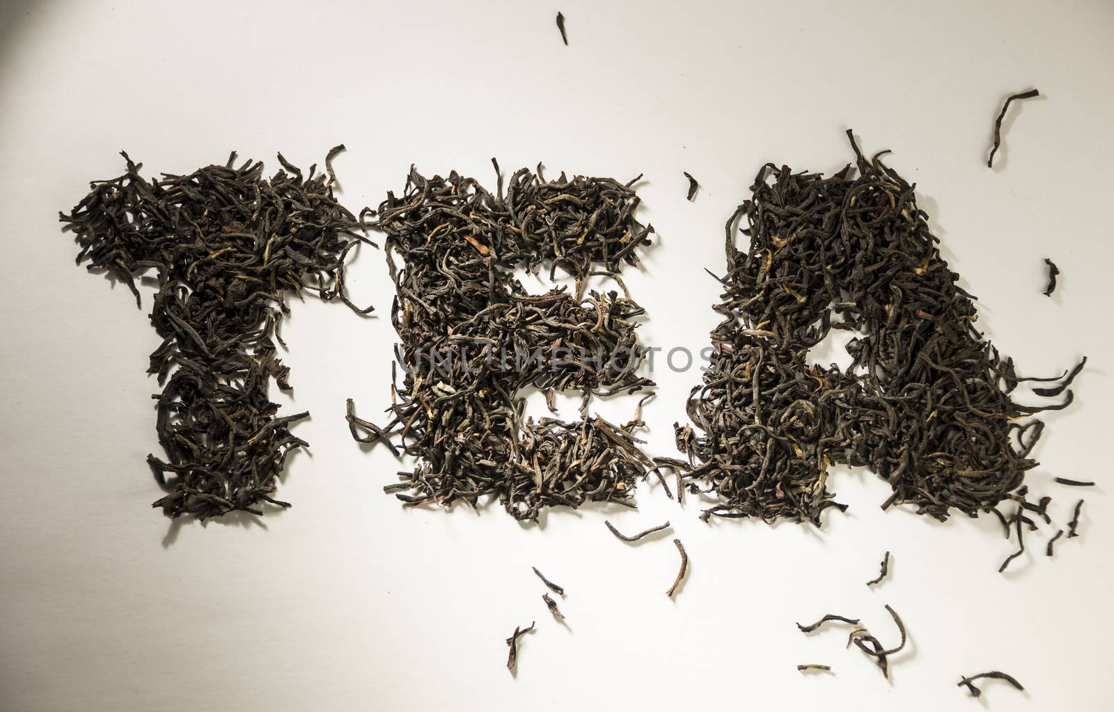 inscription tea from black tea leaves on a white background.