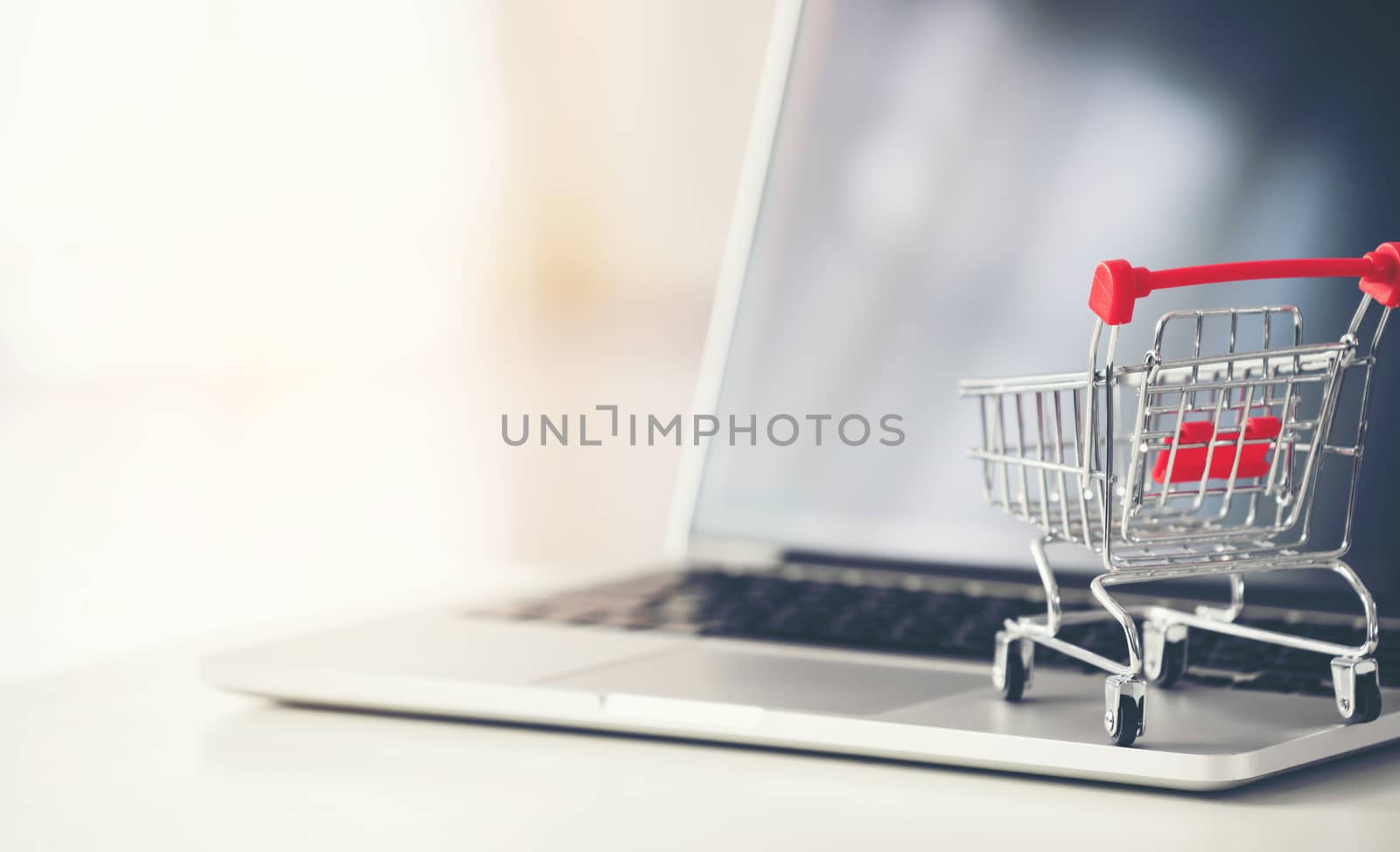 shopping cart with laptop on the desk, online shopping concept