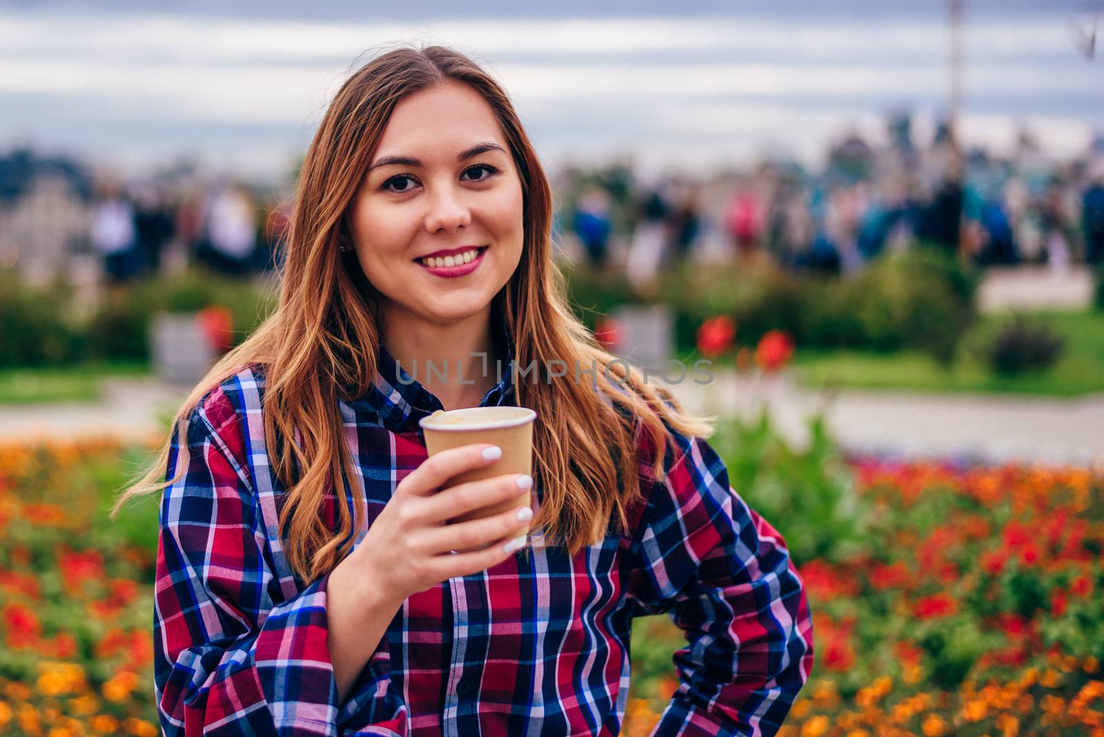 Beautiful young woman holding coffee cup and smiling by Seva_blsv