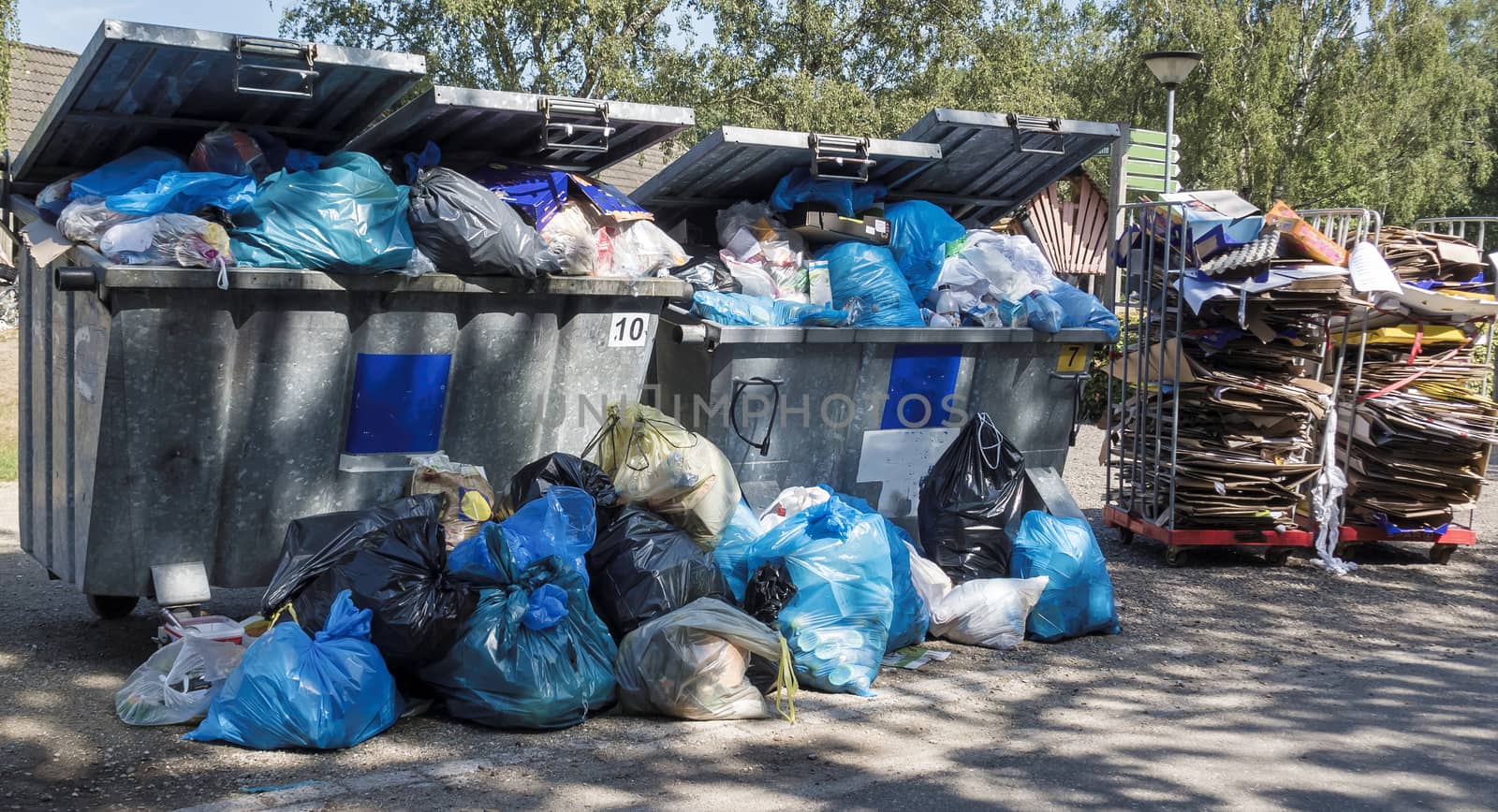 garbage containers that are full of garbage and junk because the collection service strikes and the bins do not empty