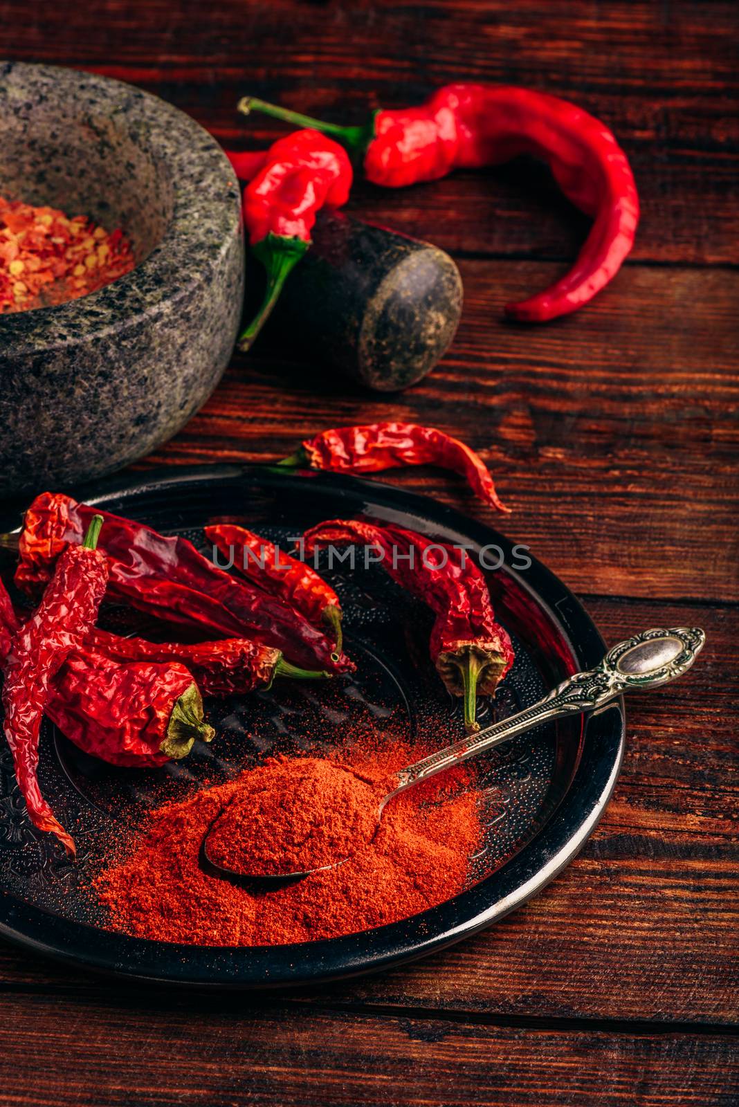 Ground and dried red chili peppers on metal tray