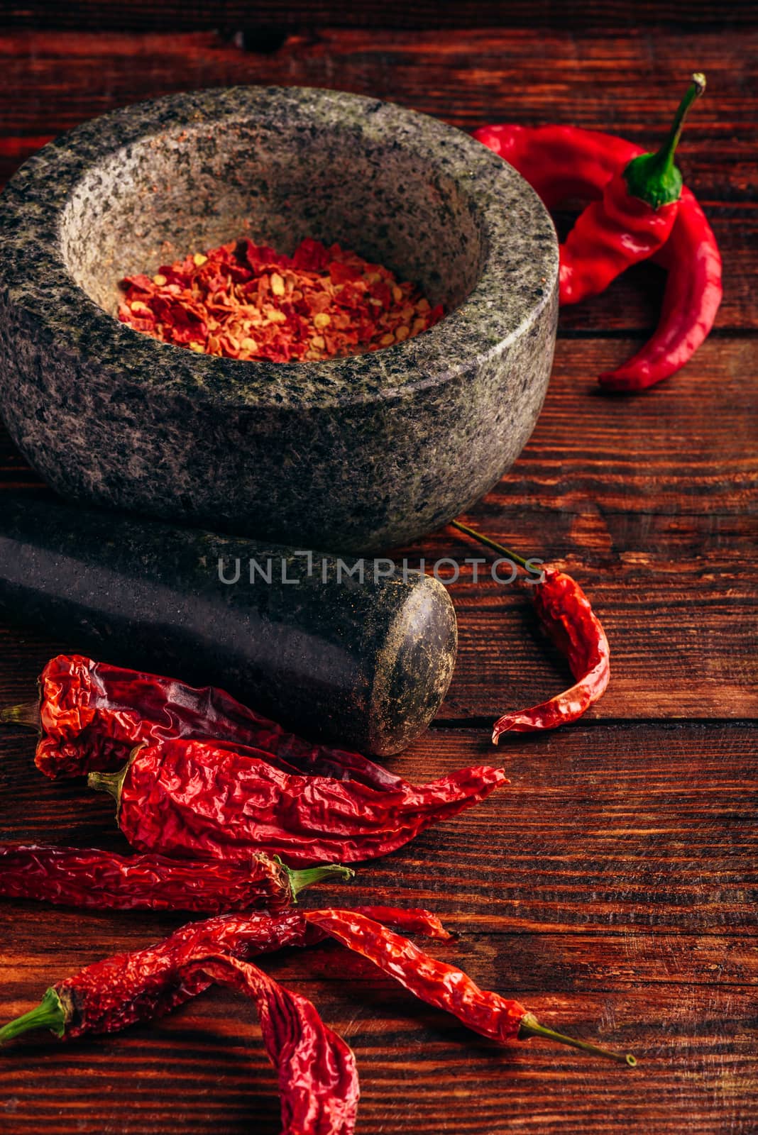 Dried and crushed red chili pepper in stone mortar