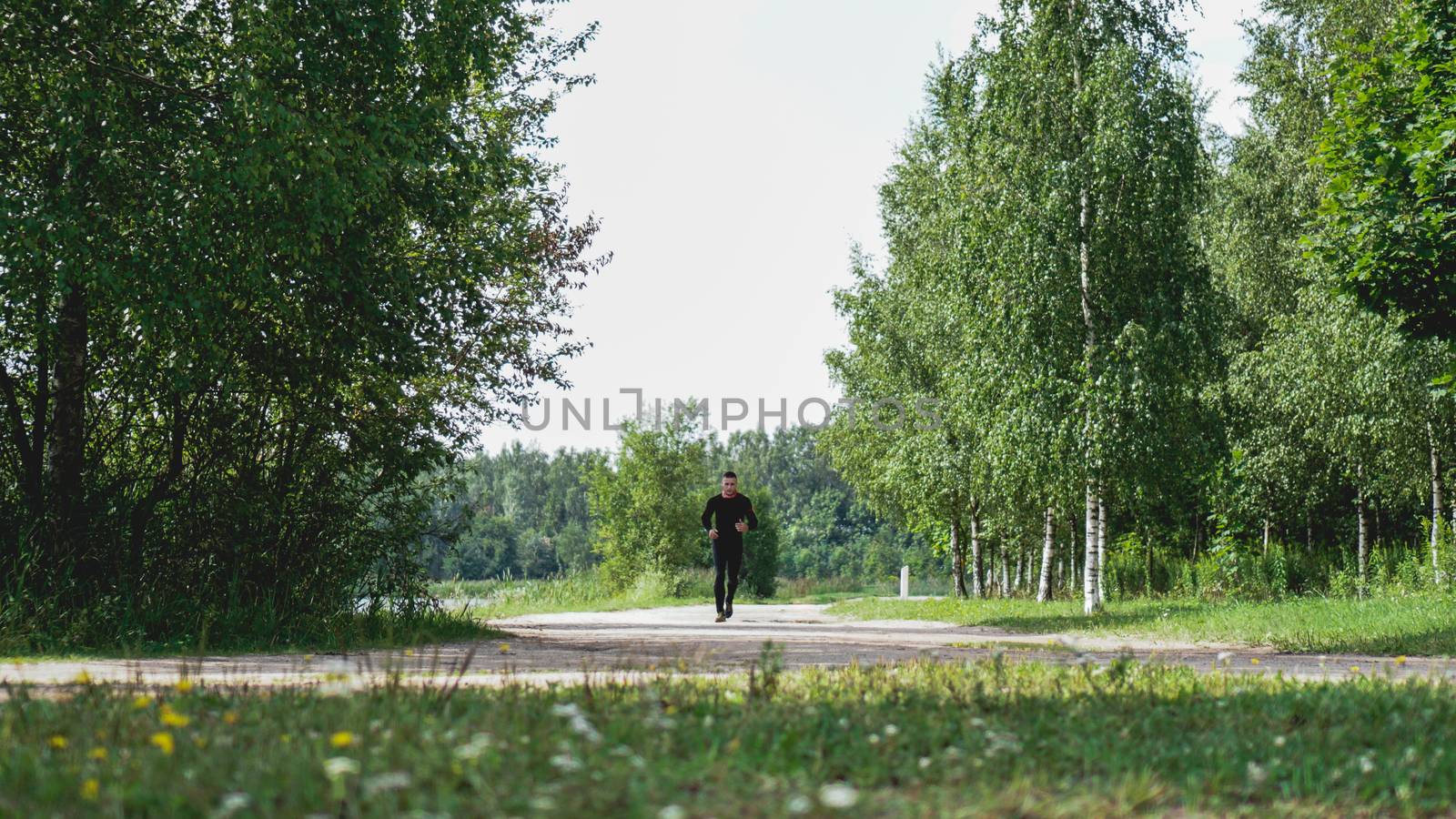 Healthy lifestyle - young man running in green forest
