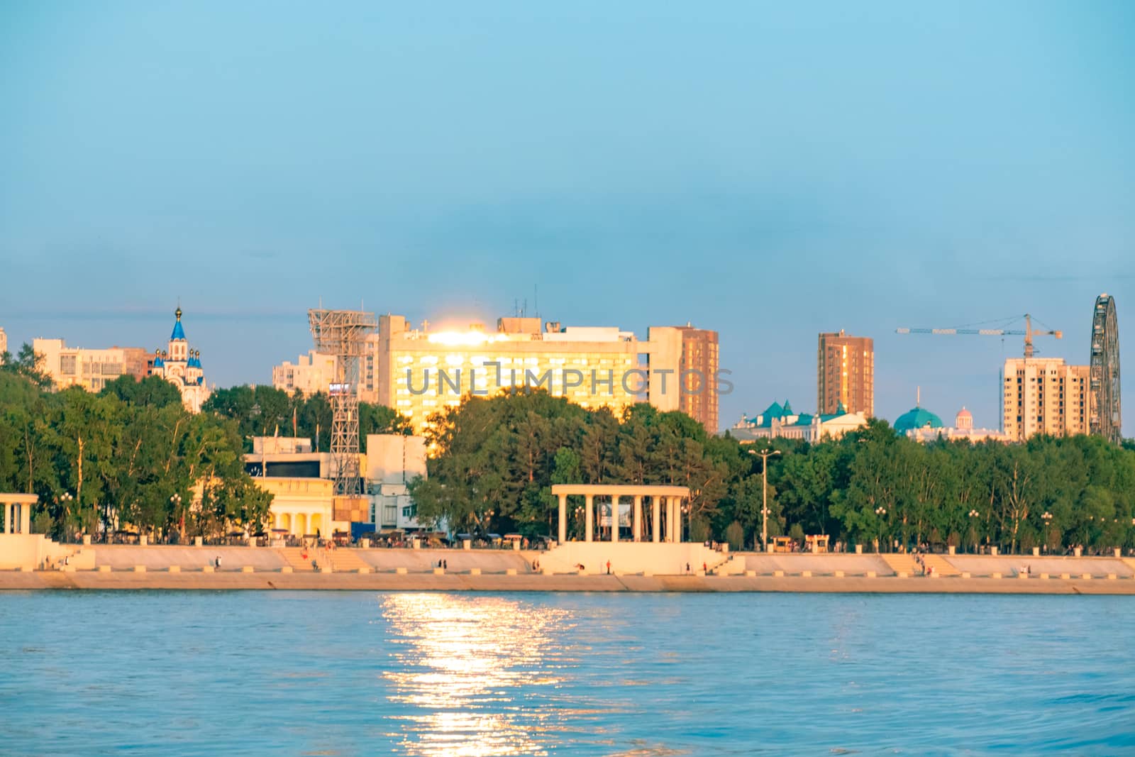 View of the city of Khabarovsk from the Amur river. Urban landscape in the evening at sunset