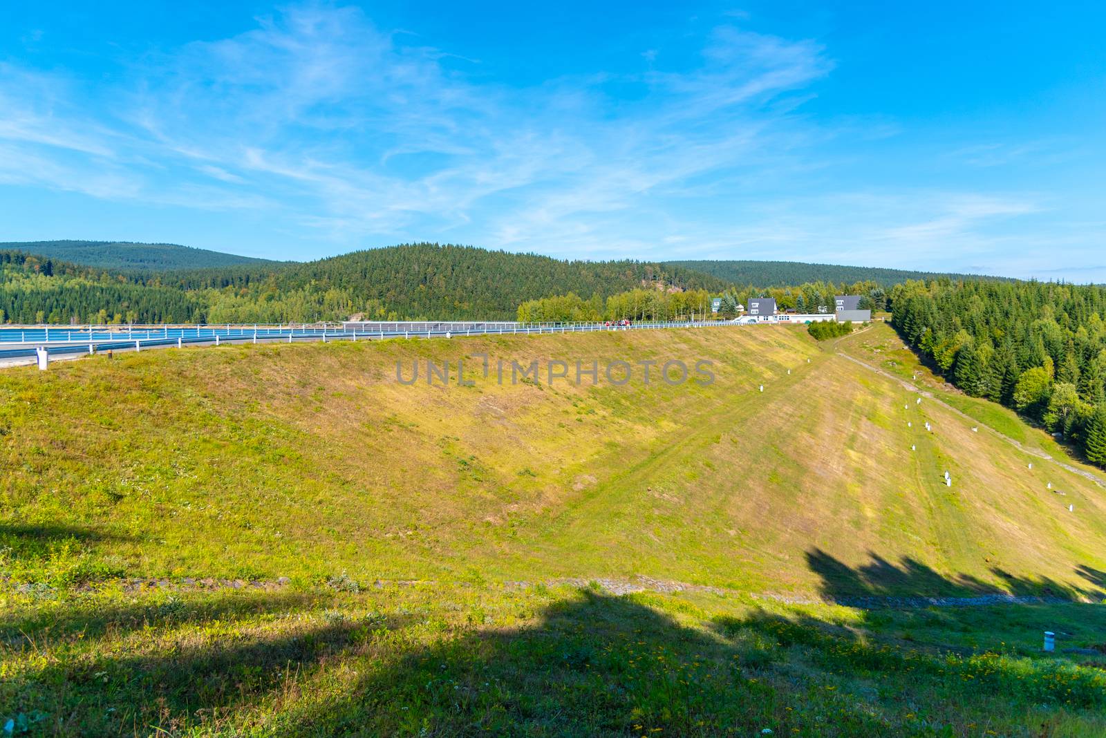 Josefuv Dul Dam, Earth-filled dam in Jizera Mountains with asphalt road on the top, Czech Republic. Sunny summer day.