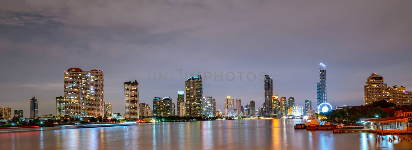 Bangkok cityscape of river front modern building in Thailand. Beautiful night scene of river,downtown building, sky and white clouds in Thailand. Asia travel and tourist. Bangkok modern office. by Fahroni