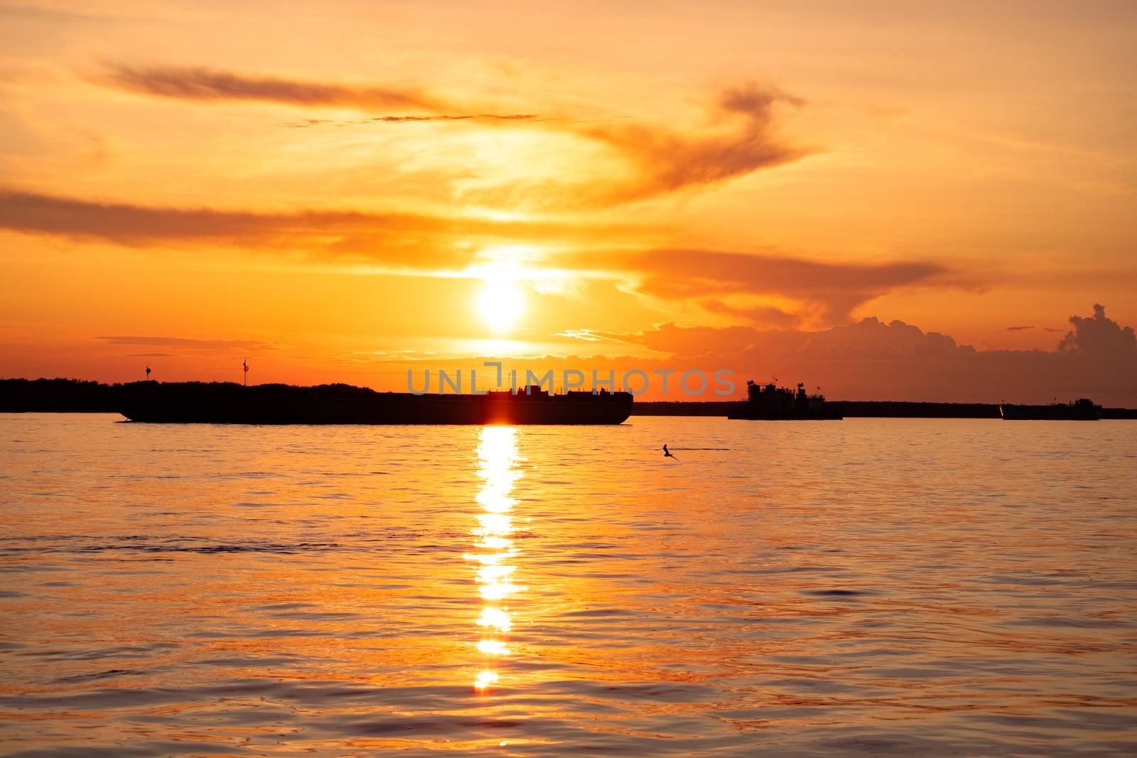 Sunset on the embankment of the Amur river in Khabarovsk. The sun set over the horizon. The embankment is lit by lanterns.