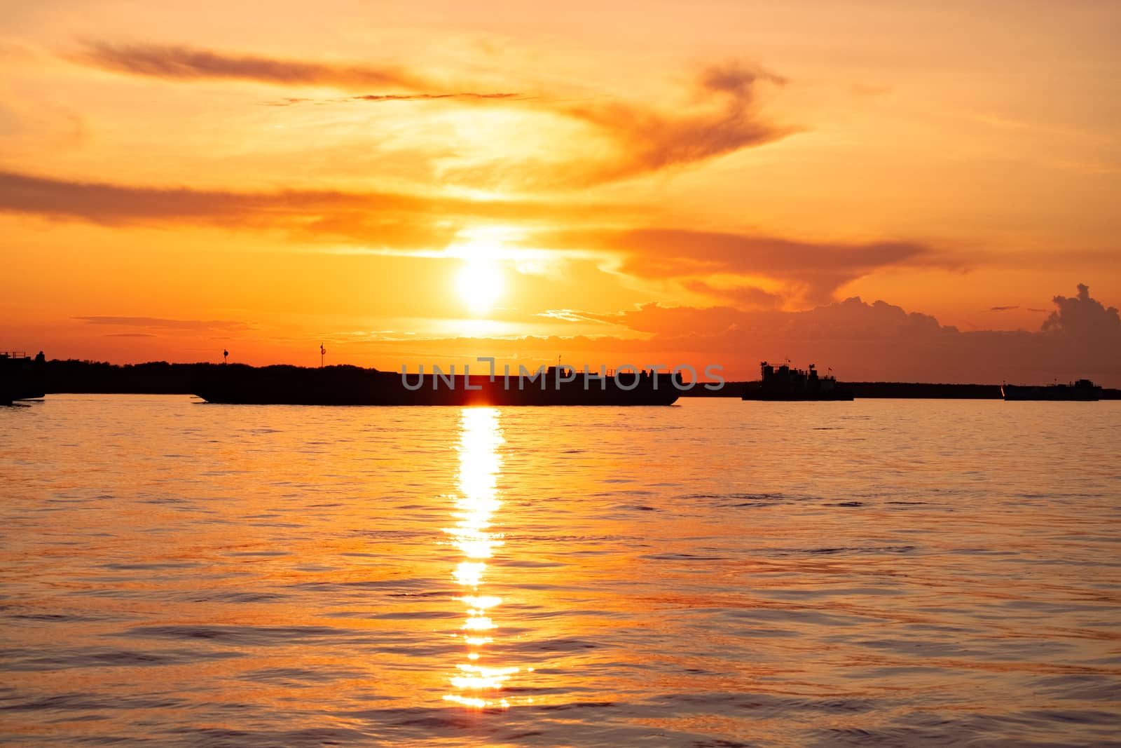 Sunset on the embankment of the Amur river in Khabarovsk. The sun set over the horizon. The embankment is lit by lanterns.