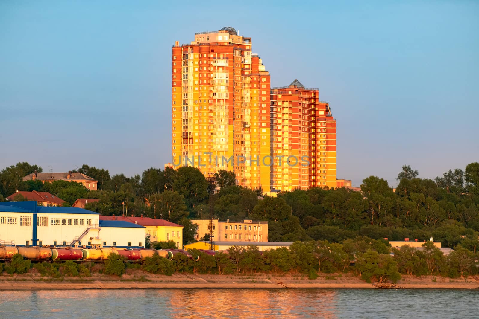 View of the city of Khabarovsk from the Amur river. Urban landscape in the evening at sunset. by rdv27