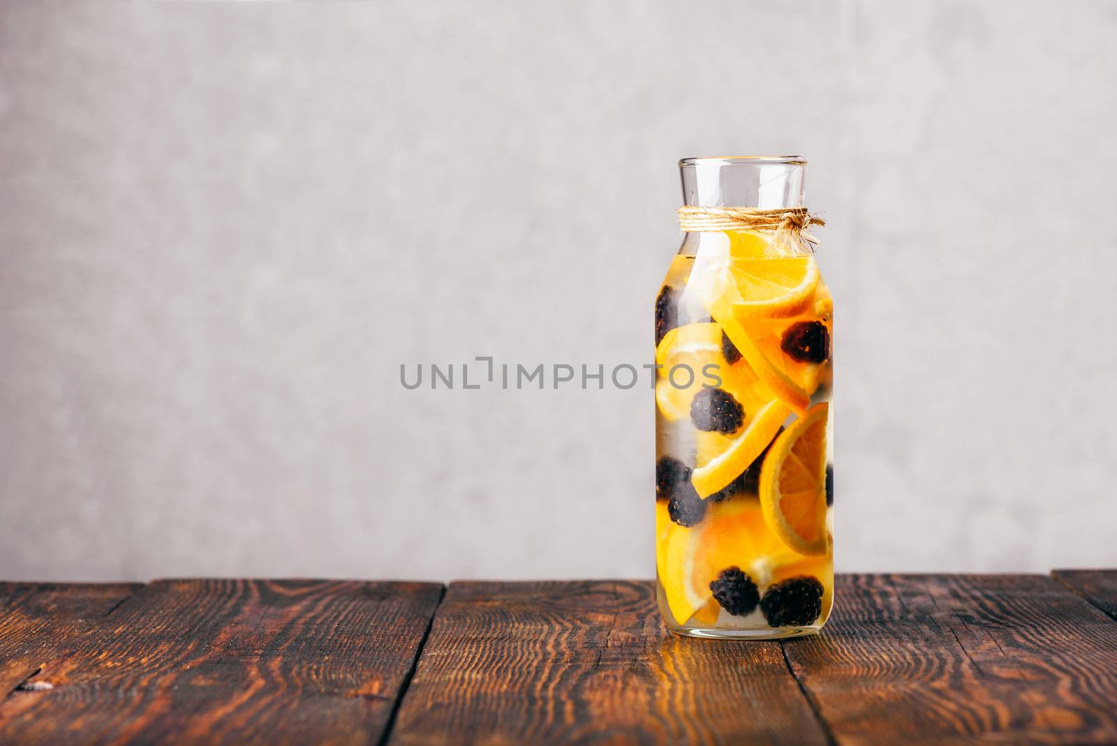 Bottle of Detox Water Infused with Sliced Raw Orange and Fresh Blackberry.