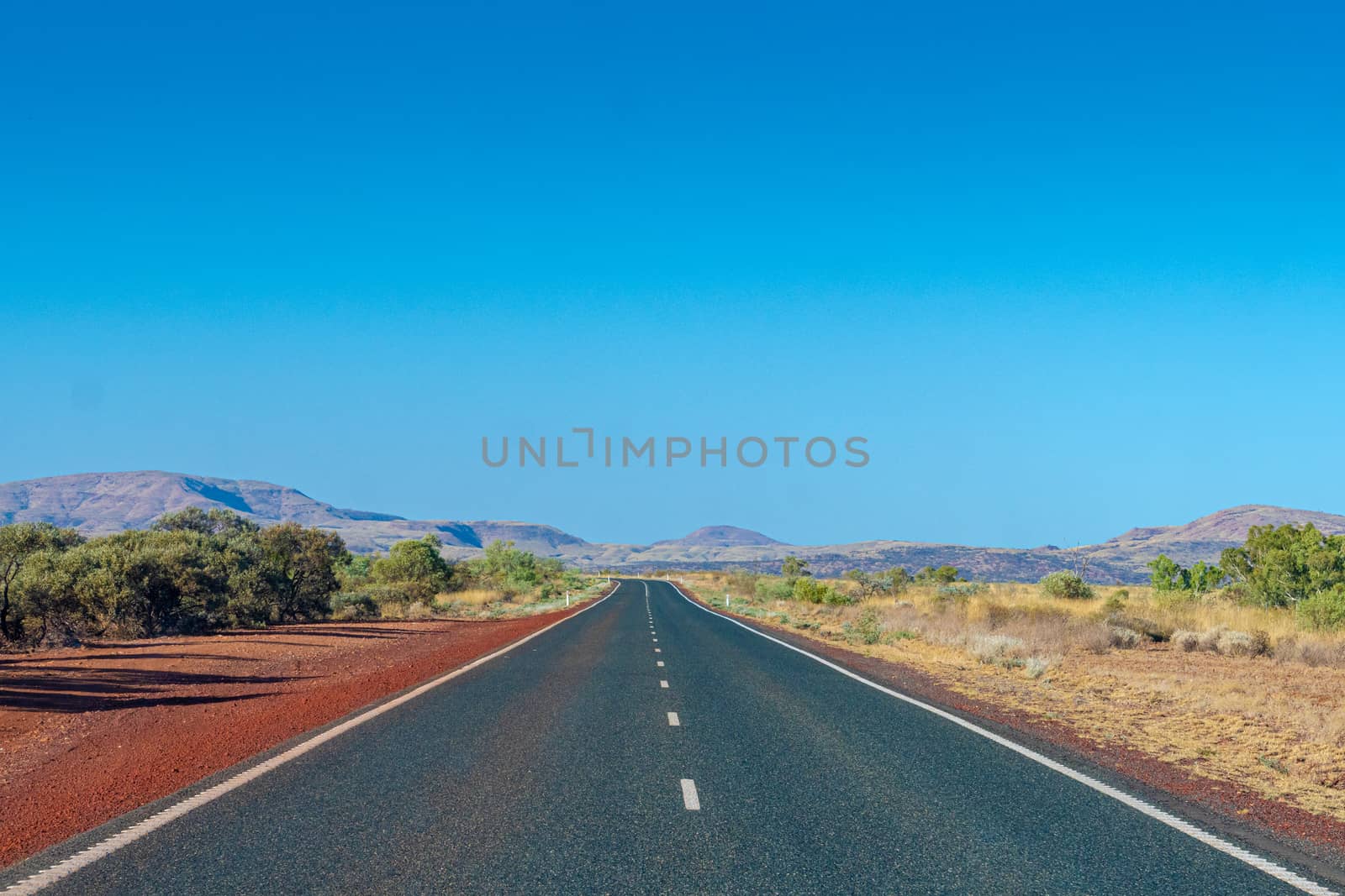 Dark tarmac road in Australian Outback around Cheela Plains Karijini National Park Australia