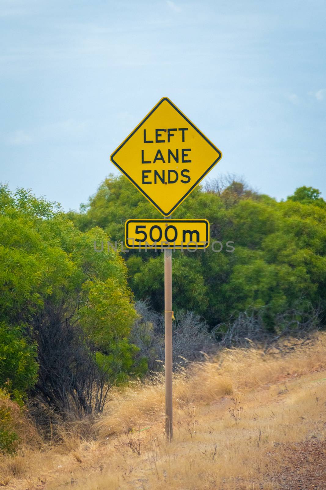 Left lane ends in 500 meters street sign next to australian road