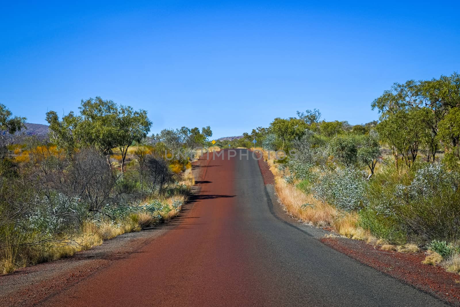 Road at Karijni National Park colored half red by desert dust and sand