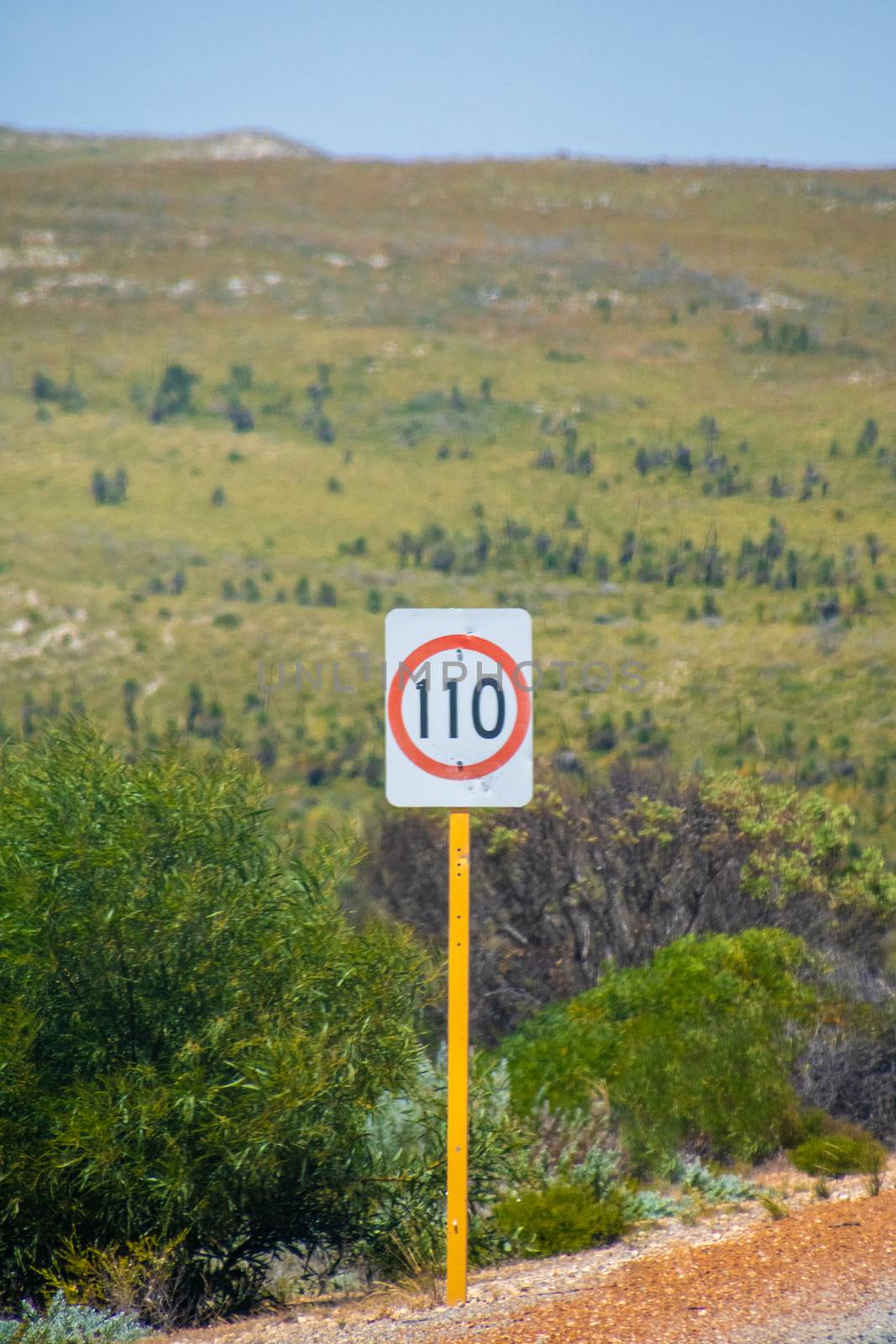 Speed limit 110 kph street sign next to an Australian road