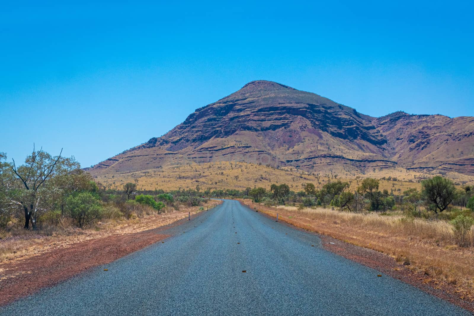 Street without road marking leading through Karjini National Park Australia