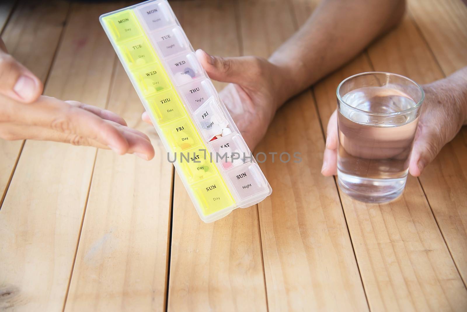 Doctor is assist patient to eat medicine tablet in pillbox correctly - people medical concept