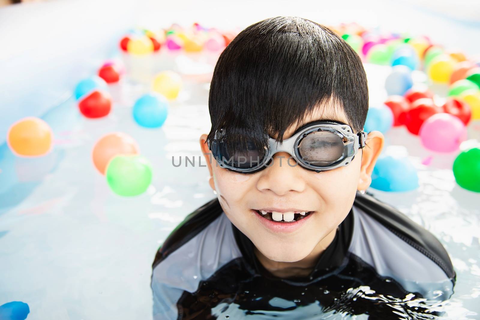 Boy playing with colourful ball in small swimming pool toy by pairhandmade