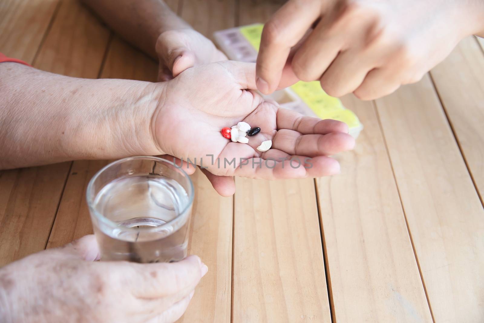 Doctor is assist patient to eat medicine tablet in pillbox correctly by pairhandmade